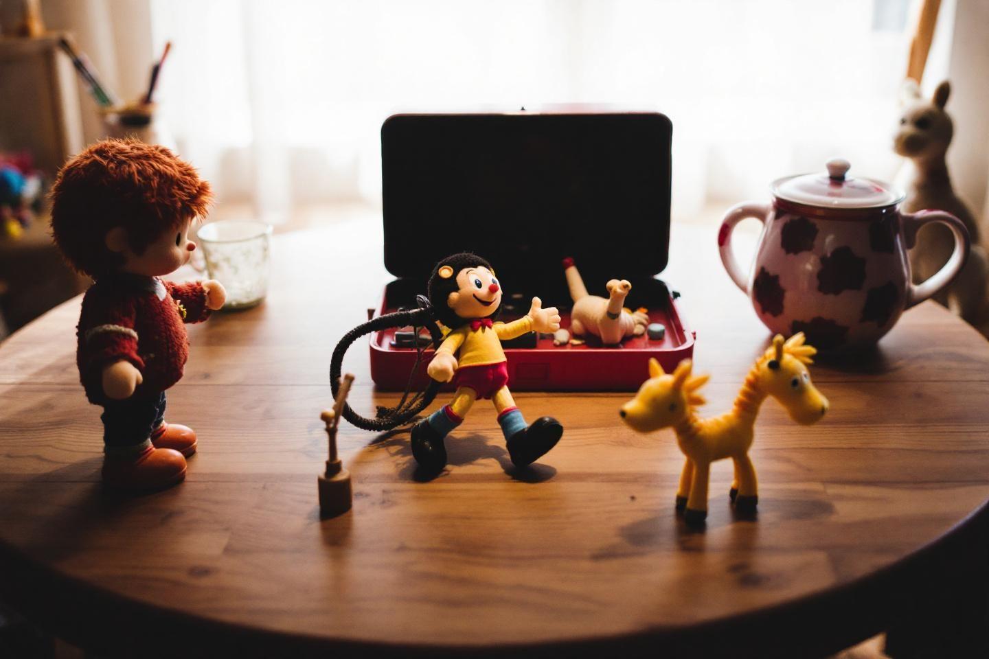 Figurines ludiques pos&eacute;es pr&egrave;s d'un ordinateur portable sur table en bois