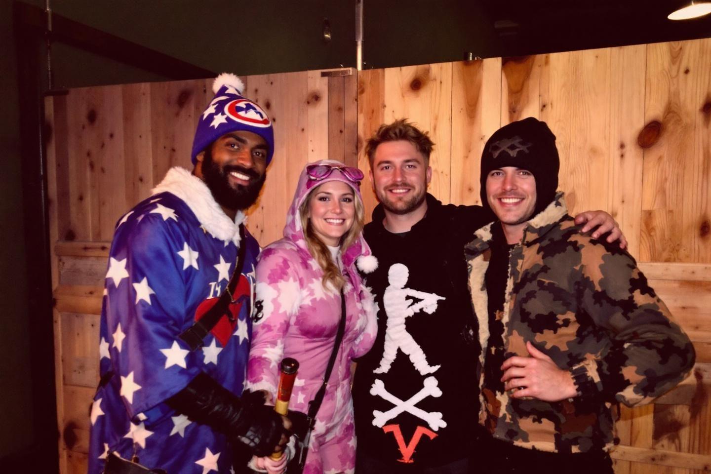 Quatre personnes souriantes en v&ecirc;tements color&eacute;s posent ensemble