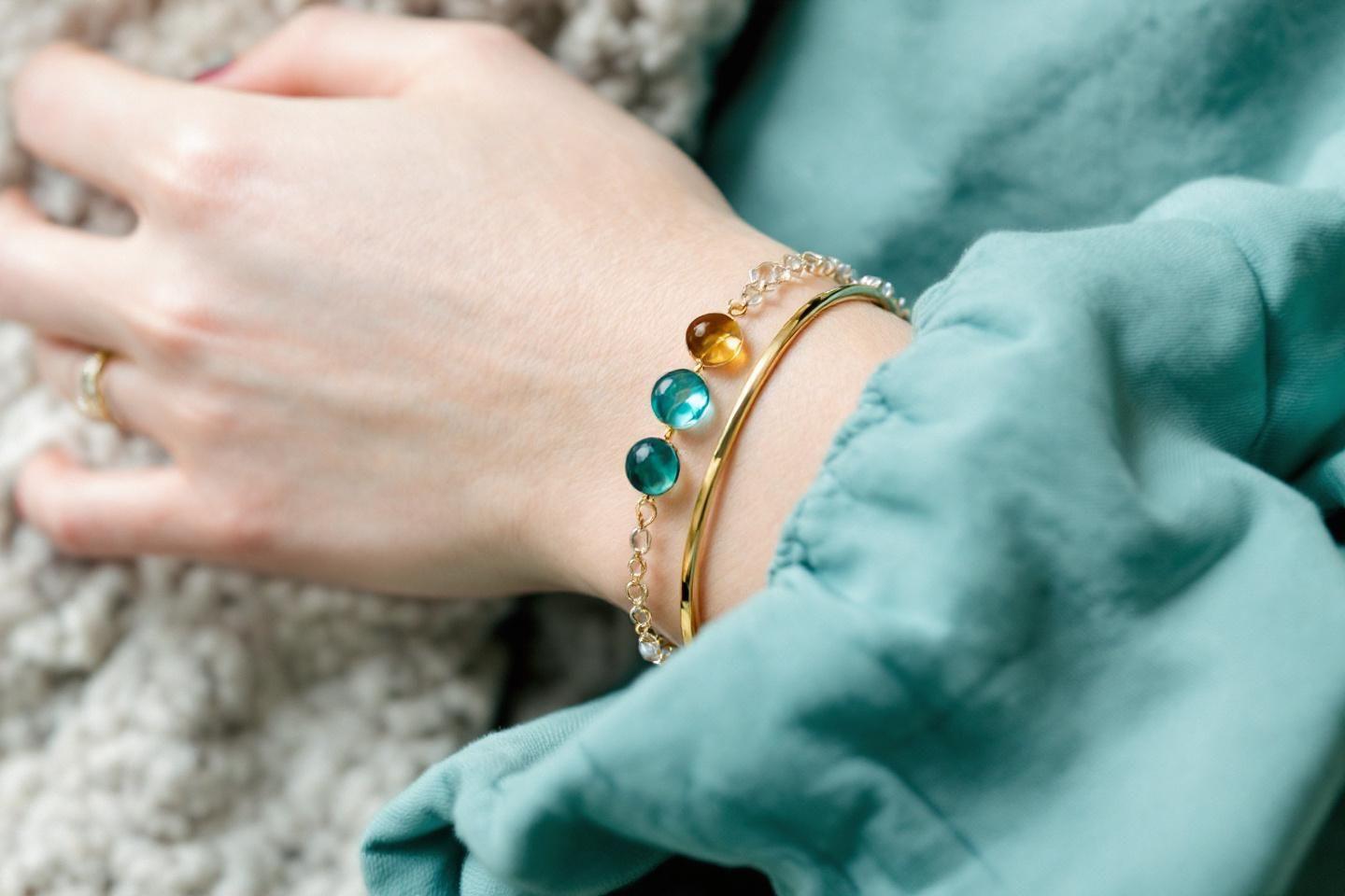 Bracelet de chaîne dorée avec perles bleues turquoise sur poignet